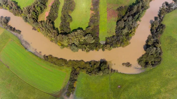 Murky river bend during floods.