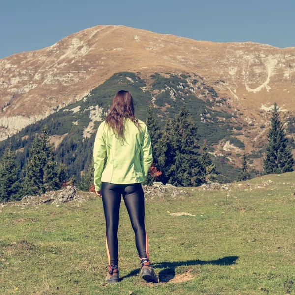 Atraktivní bruneta pózuje v horách. — Stock fotografie