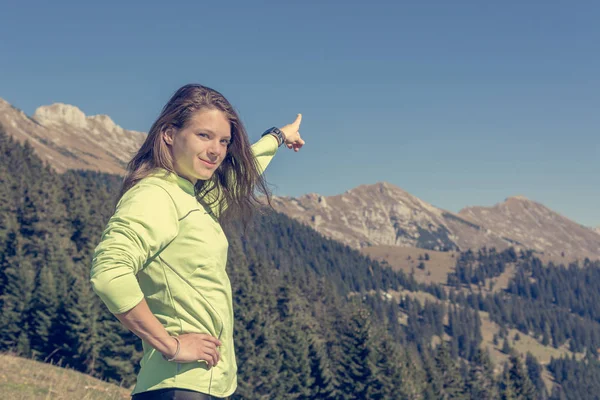 Caminhante feminina apontando para o pico da montanha . — Fotografia de Stock