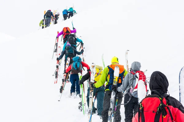 Group of cross-country skiers ascending a steep slope. — Stock Photo, Image