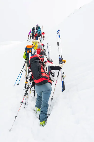 Group of cross-country skiers ascending a steep slope. — Stock Photo, Image