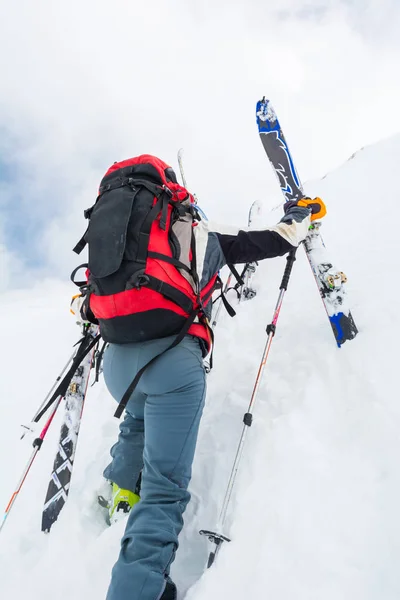 Skiërs klimmen een steile helling. — Stockfoto