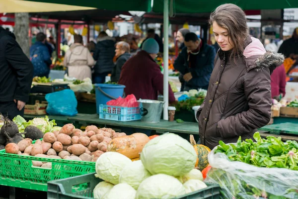 Young woman buying localy grown vegetables.