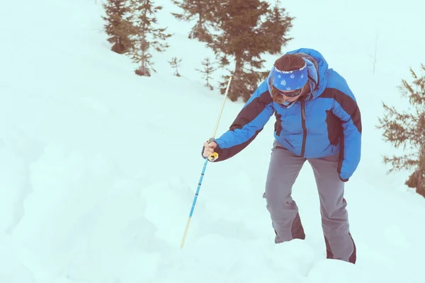 Female rescuer searching for avalanche victim.