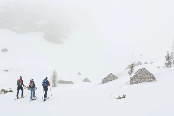 Groep skiërs verkennen van de ruïnes van gebouwen van de grote oorlog. — Stockfoto