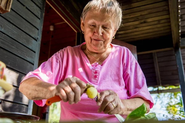 Donna anziana pelare le patate . — Foto Stock