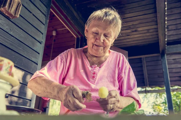 Donna anziana pelare le patate . — Foto Stock