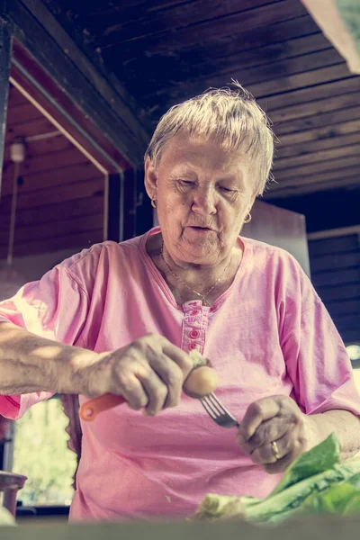 Donna anziana pelare le patate . — Foto Stock