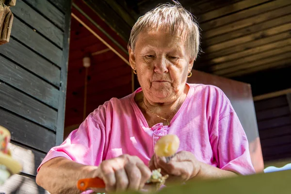 Donna anziana pelare le patate . — Foto Stock