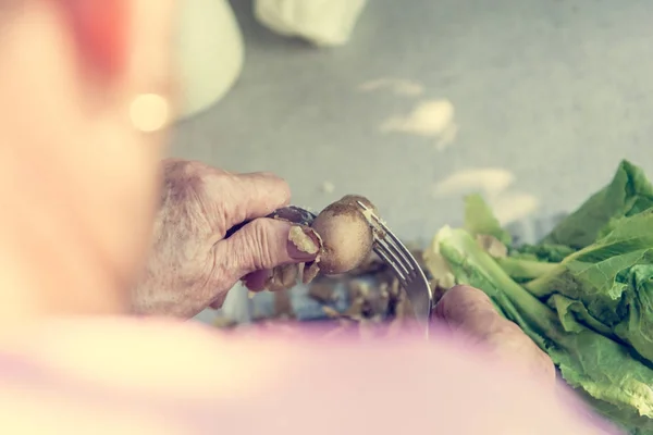 Primo piano delle mani anziane che respirano patate . — Foto Stock