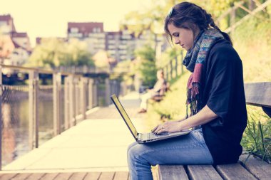 Nehir dizüstü bilgisayar kullanan genç kadın.