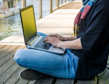 Nehir, bir parkta dizüstü bilgisayar kullanan genç kadın.