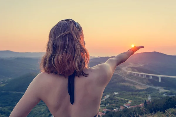 Attraktive Brünette mit einer Sonne in der Hand. — Stockfoto