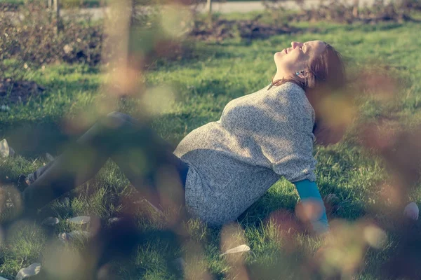 Werdende Mutter liegt auf Gras im öffentlichen Park. — Stockfoto