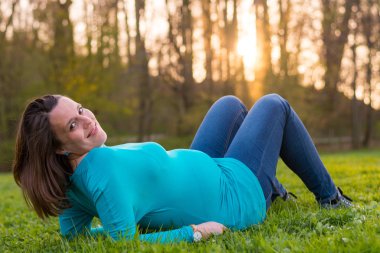 Anne çimenlerin üzerinde rahatlatıcı bekliyor.