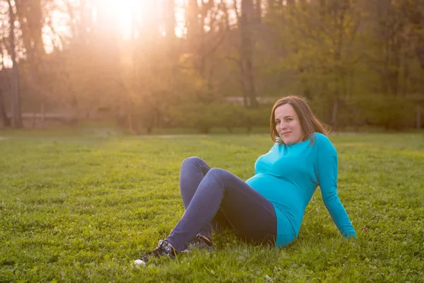 Expecting mother relaxing in a park. — Stock Photo, Image