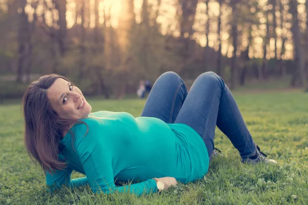 Werdende Mutter entspannt im Gras. — Stockfoto