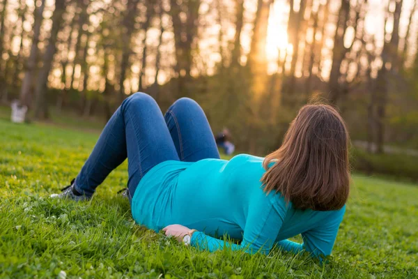 Expecting mother relaxing on grass. — Stock Photo, Image