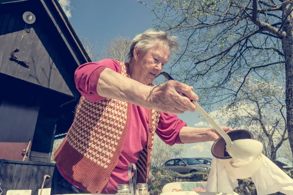 Bejaarde vrouw serveren een lunch buiten. — Stockfoto