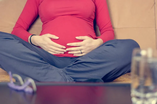 Gros plan de la mère mains caressant son ventre enceinte . — Photo