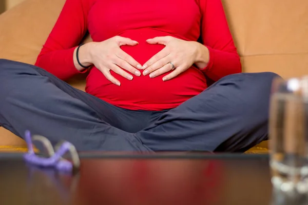 Gros plan de la mère mains caressant son ventre enceinte . — Photo