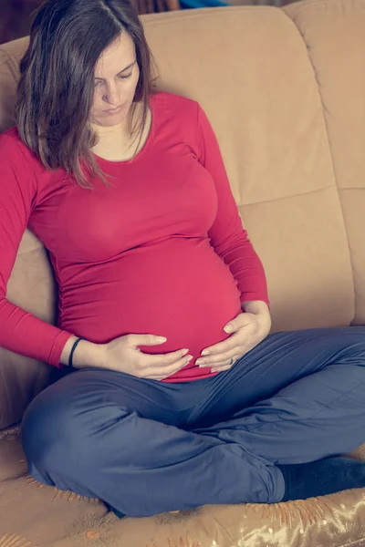 Nahaufnahme von mütterlichen Händen, die ihren schwangeren Bauch streicheln. — Stockfoto