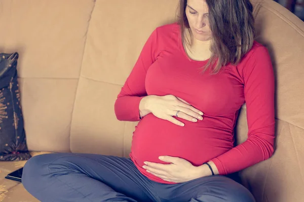 Gros plan de la mère mains caressant son ventre enceinte . — Photo