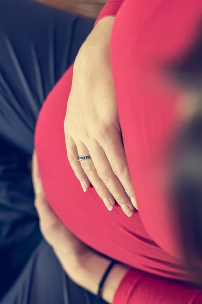 Dół widok matki, trzymając jej brzuch w ciąży. — Zdjęcie stockowe