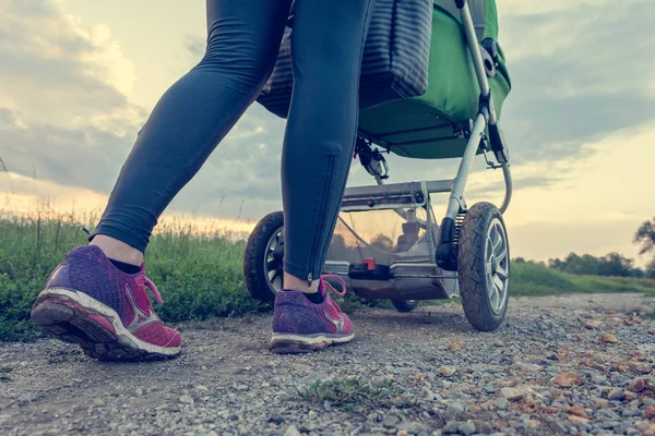 Active mother running with baby stroller. — Stock Photo, Image