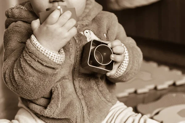 Baby leker med färgglada tegelstenar på trägolv. — Stockfoto