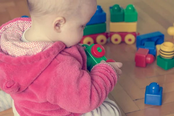 Baby játszó színes téglák fa padló. — Stock Fotó