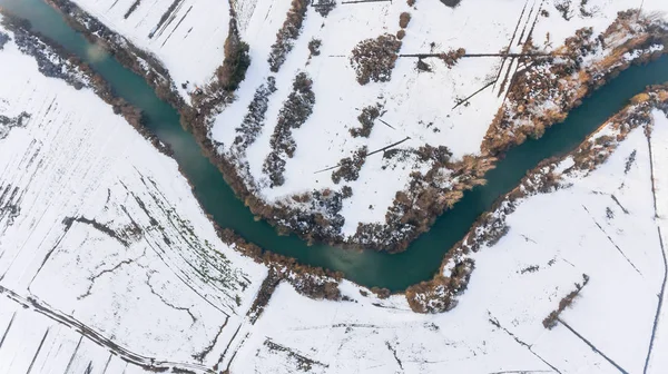 Вид з повітря на берег річки, що проходить повз снігові покриті поля . — стокове фото