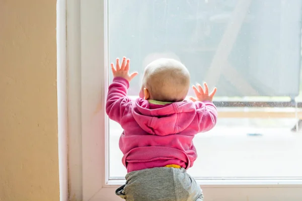 Дитяча дівчинка дивиться через балкон . — стокове фото