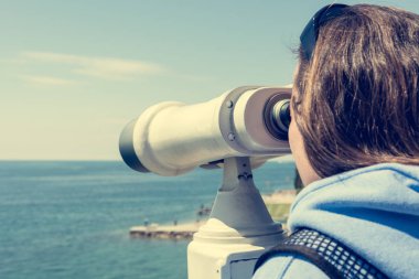 Deniz kenarında sikke işletilen dürbün görünümlü kadın.