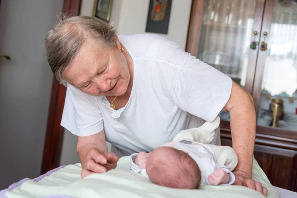 Glückliche Großmutter streichelt neugeborenes Baby. — Stockfoto