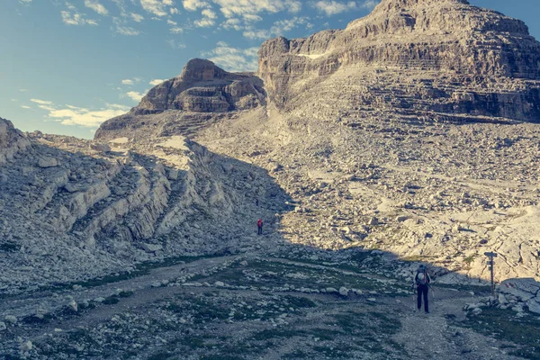 Kayalık bir yol mücadele uzun yürüyüşe çıkan kimse. — Stok fotoğraf