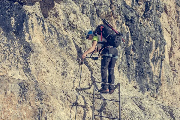 Dikey duvar mücadele için metal merdiven artan dağcı. — Stok fotoğraf
