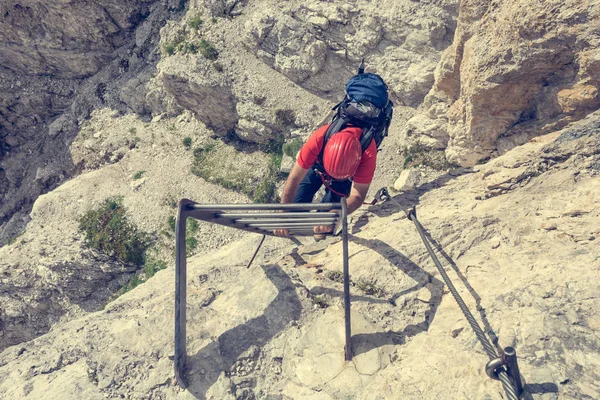 Horolezec vzestupně kovový žebřík k řešení svislé stěny. — Stock fotografie