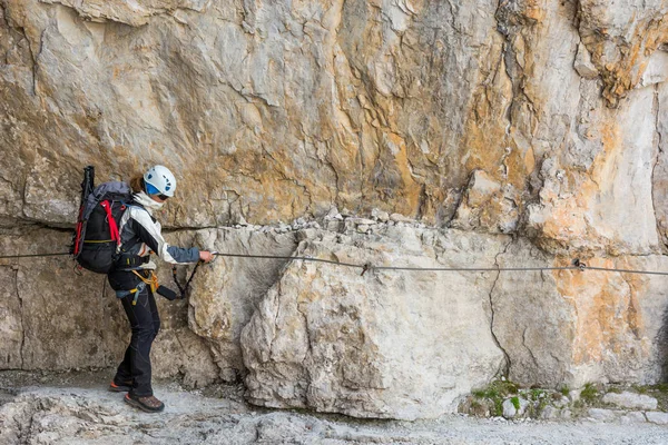 Climber walking on narrow ledge protected by via ferrata set. — Stock Photo, Image