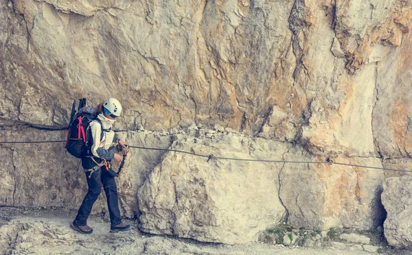 Climber walking on narrow ledge protected by via ferrata set. — Stock Photo, Image