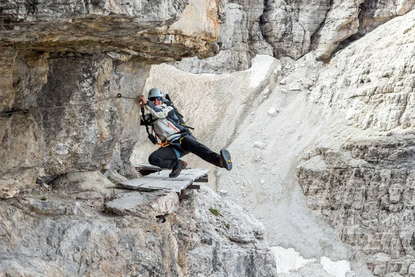Female climber having some fun on dangerously narrow ledge with via ferrata set. — Stock Photo, Image