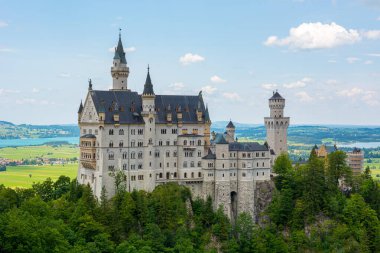 Ormanın üzerinde yükselen beyaz peri masalı şatosu.