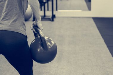 Elinde mor bir kettlebell tutan kadının ayrıntıları..