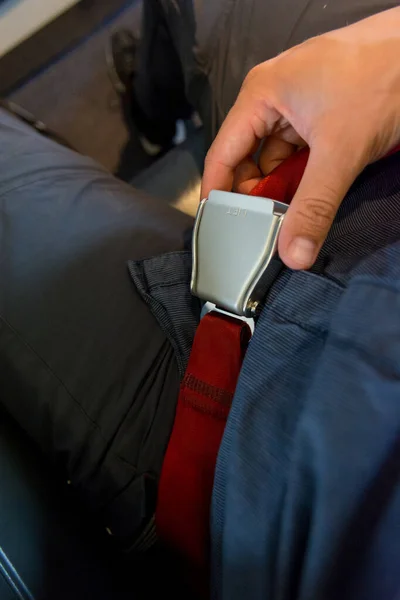 Persona ajustando el cinturón de cintura y preparándose para el despegue del avión . — Foto de Stock