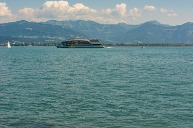 Güneşli bir günde, lüks bir tekne dağ gölünde yelken açıyor..
