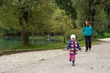 Anne ve kızı göl kıyısında sonbahar yürüyüşüne çıktılar..