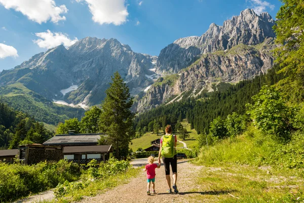 Bakifrån utsikt över mor och dotter vandring en pittoresk bergsdal. — Stockfoto