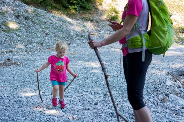 Madre e hija haciendo senderismo con bastones en un sendero de montaña . — Foto de Stock