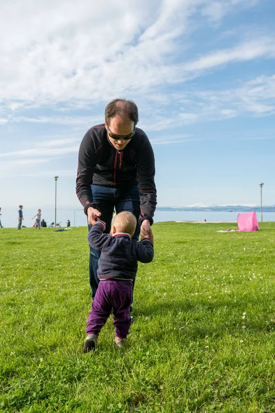 Menina bonito aprender a andar com seu pai em um parque . — Fotografia de Stock