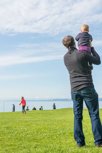 Zadní pohled na otce, jak drží svou roztomilou dcerku a dívá se na moře. — Stock fotografie